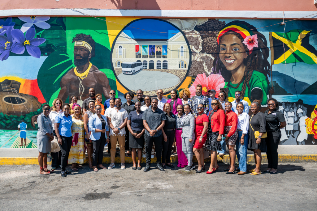 a group of people standing in front of a painted mural in Montego Bay
