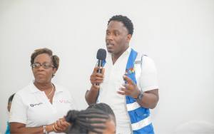 A man standing talking with the microphone a woman standing next to him