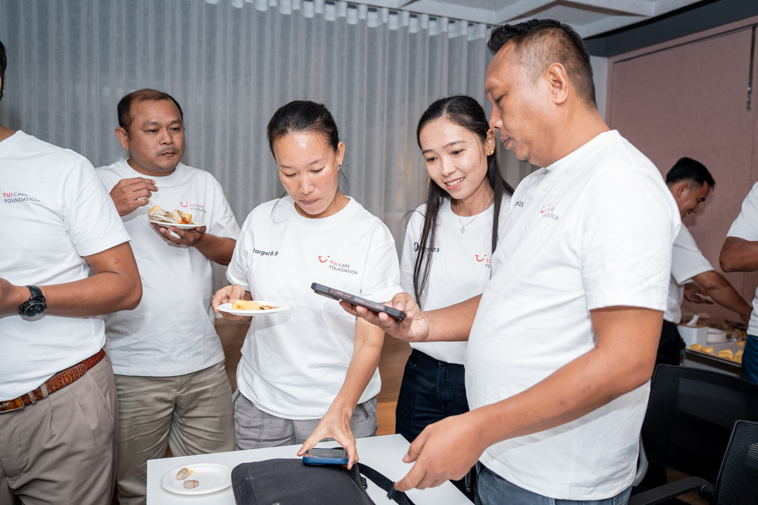 A small group of people eating and showing things on their phone