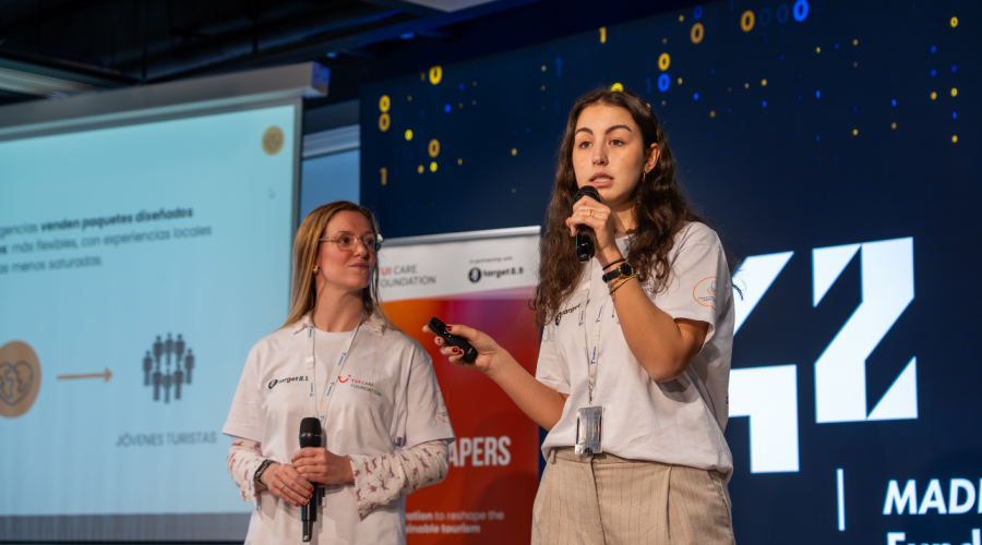 two women with a microphone presenting something on stage