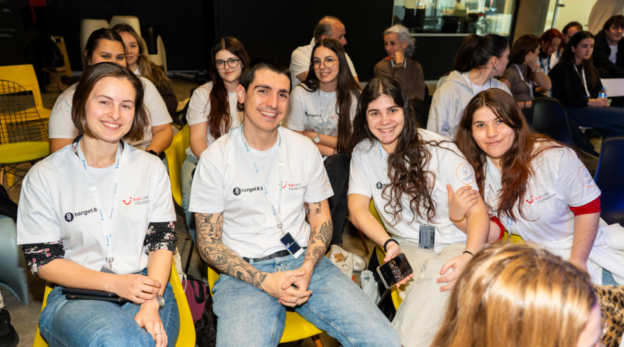 a group of people sitting in the audience and smiling into the camera