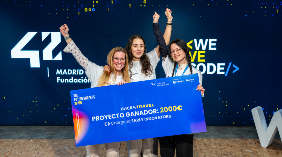 three women cheering behind a check